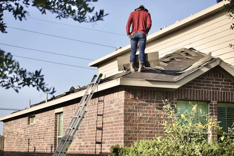 Professional roofer working on a residential roof in Colby Point